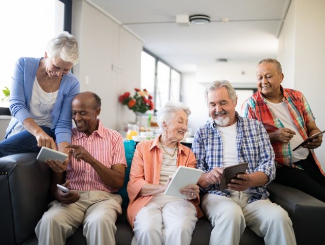 Older adults engaging with tablets, showcasing the need for digital proficiency.