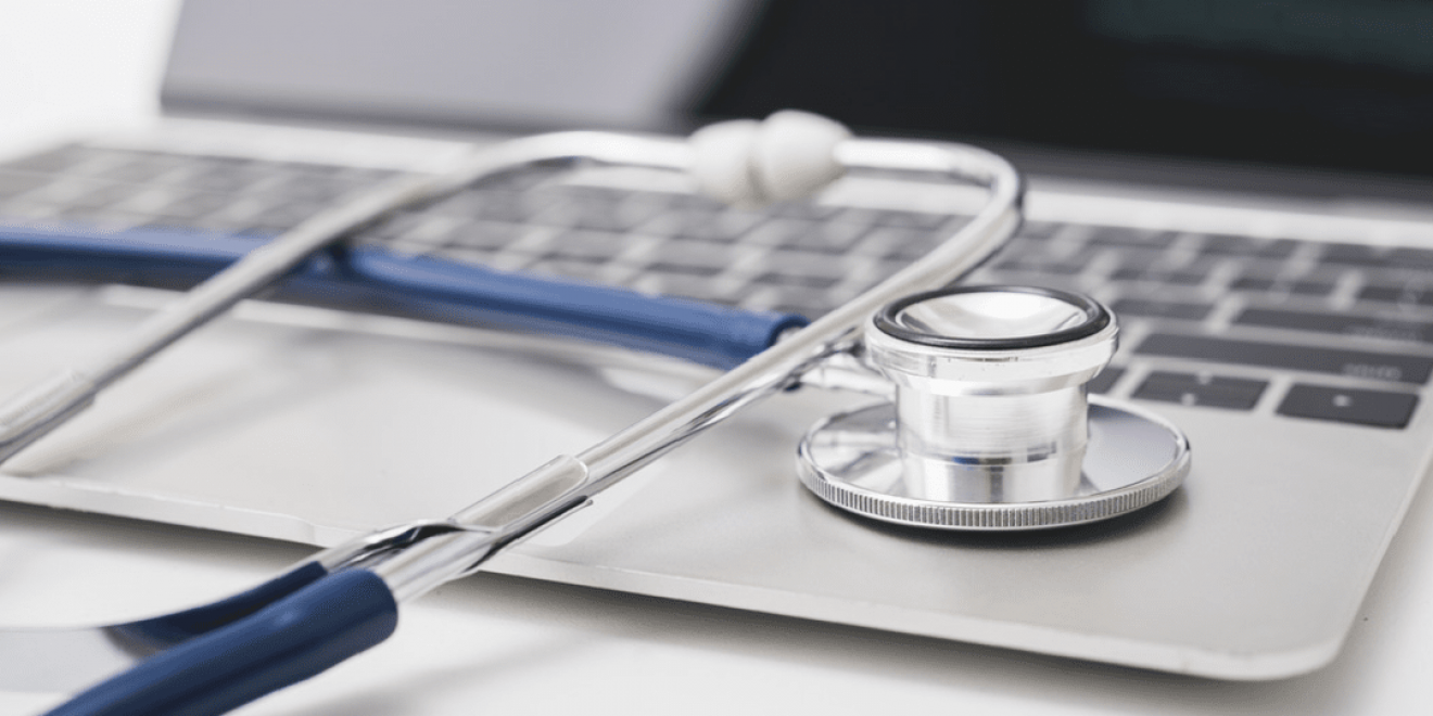 A stethoscope placed on a laptop, indicating expertise in the healthcare domain.
