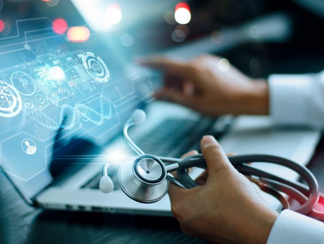 Product development life cycle – doctor using a laptop, stethoscope in hand